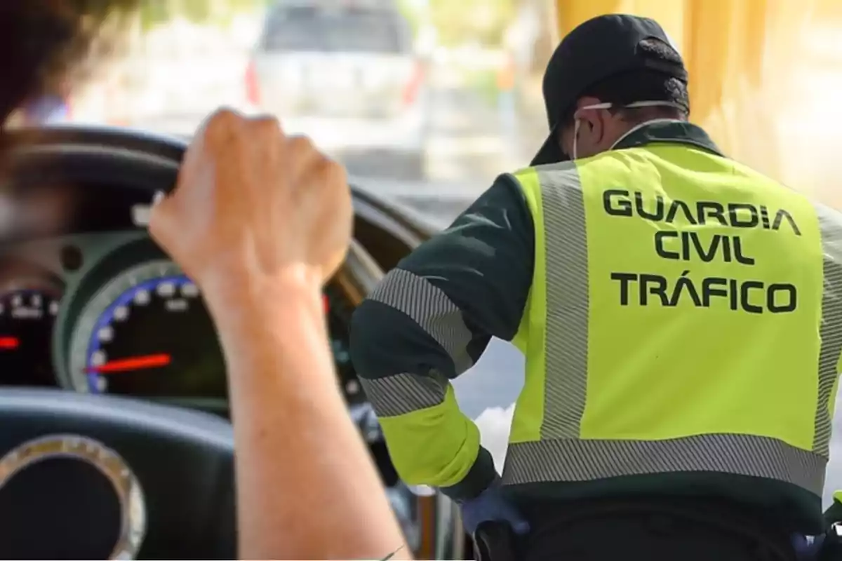 Un agente de la Guardia Civil de Tráfico con chaleco reflectante interactúa con un conductor en un control de carretera.