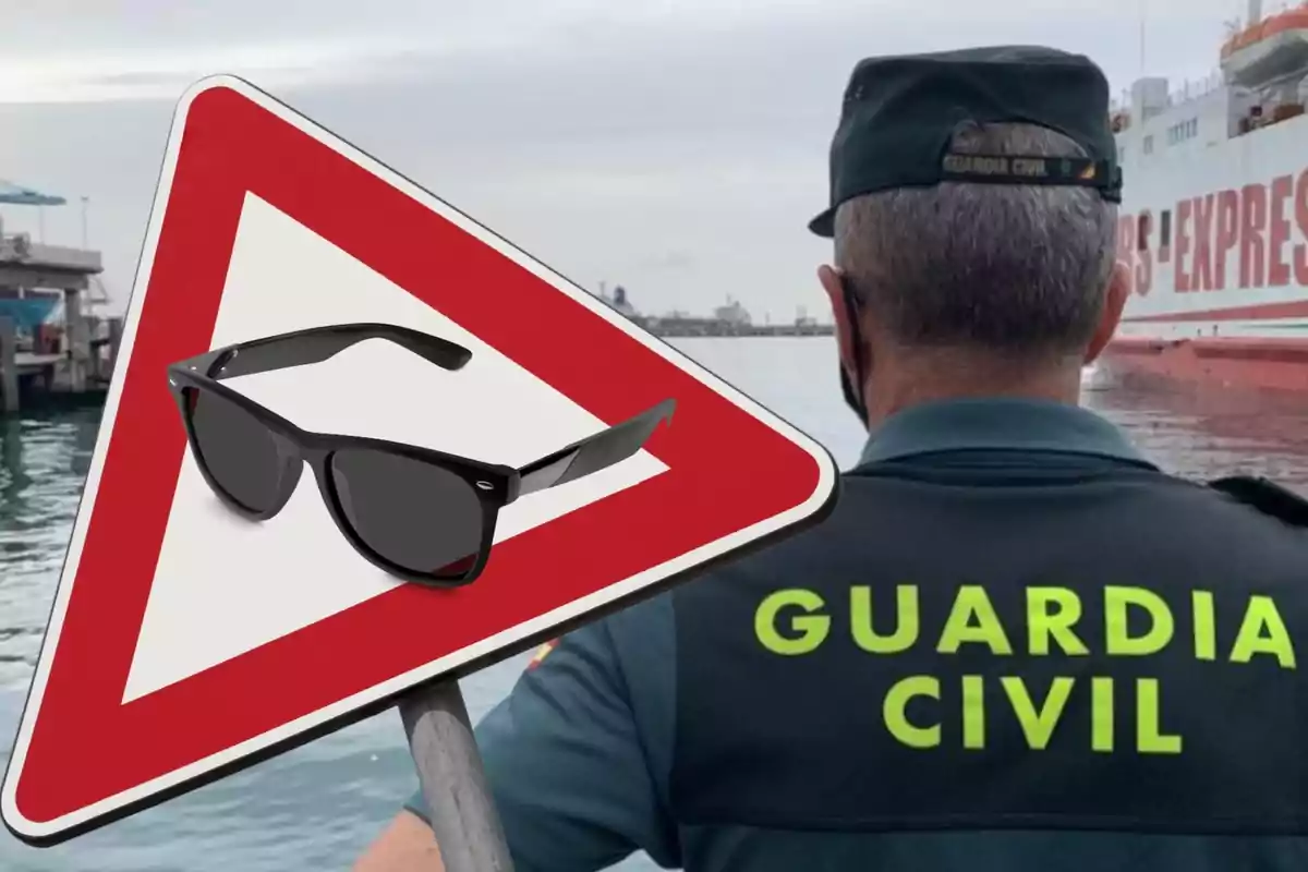 Un agente de la Guardia Civil de espaldas junto a un cartel triangular con un par de gafas de sol en su interior, en un entorno portuario.