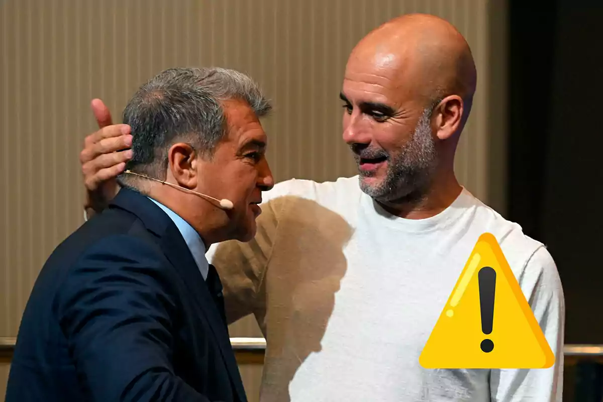 Dos hombres conversando en un evento, Laporta con un micrófono de diadema y Guardiola con una camiseta blanca, con un icono de advertencia en la esquina inferior derecha.