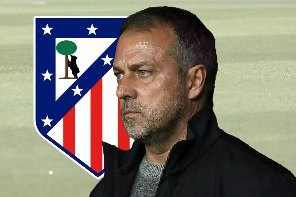 Hansi Flick with a serious expression in front of the Atlético de Madrid crest.