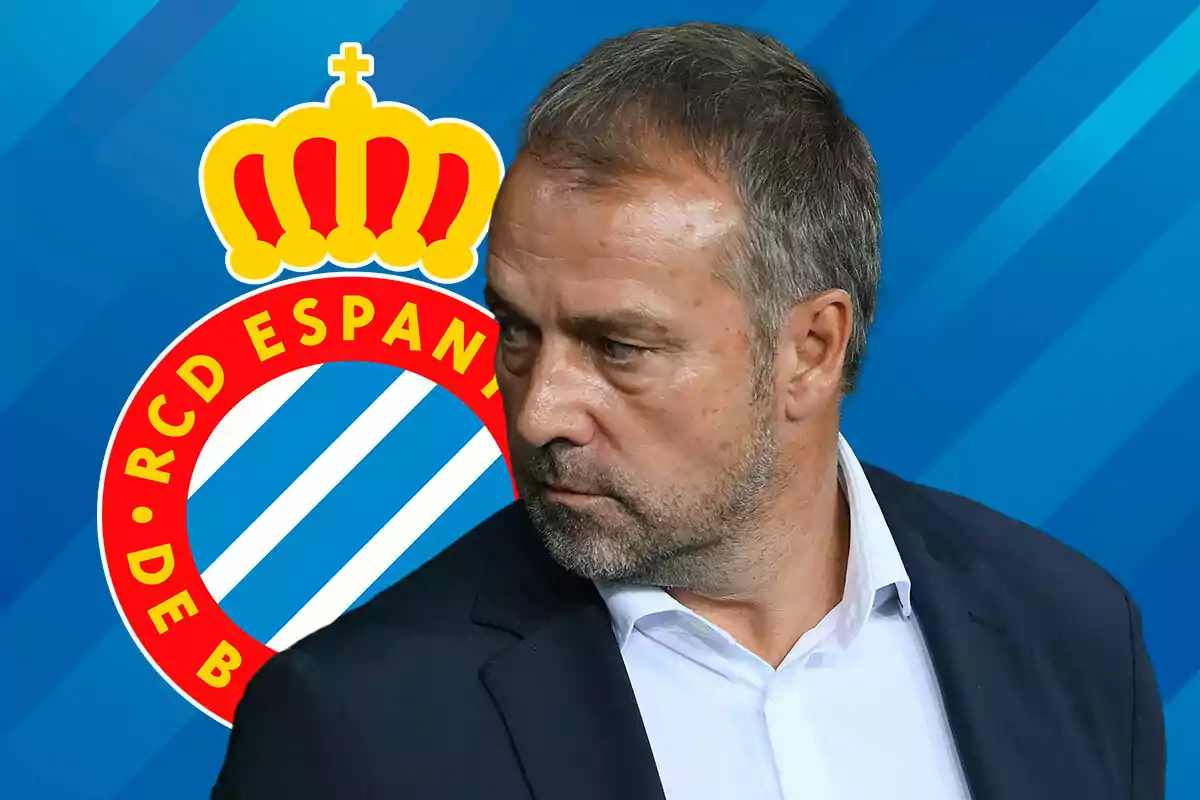 Hansi Flick in suit in front of the RCD Espanyol logo.