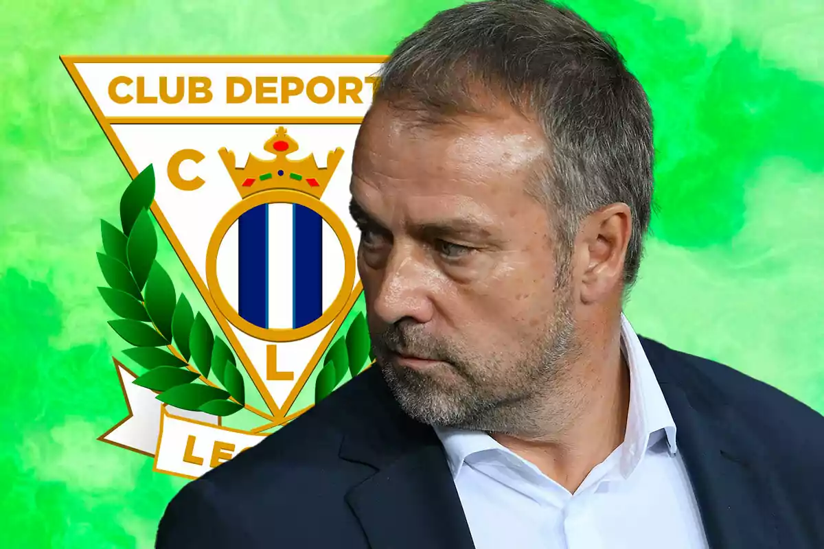 Hansi Flick in a suit in front of CD Leganés crest with a green background.