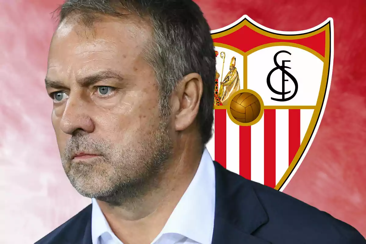 Hansi Flick con expresión seria frente al escudo del Sevilla FC.