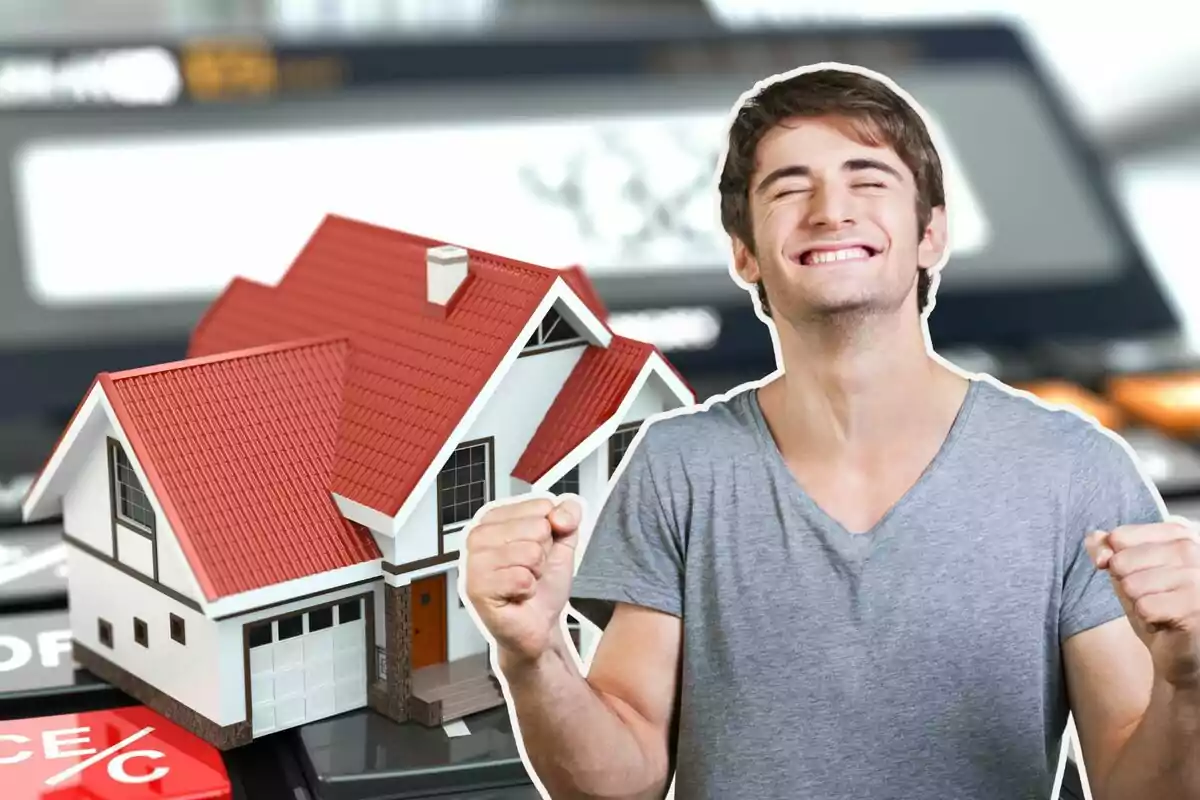 Hombre feliz con una casa en miniatura y una calculadora en el fondo.