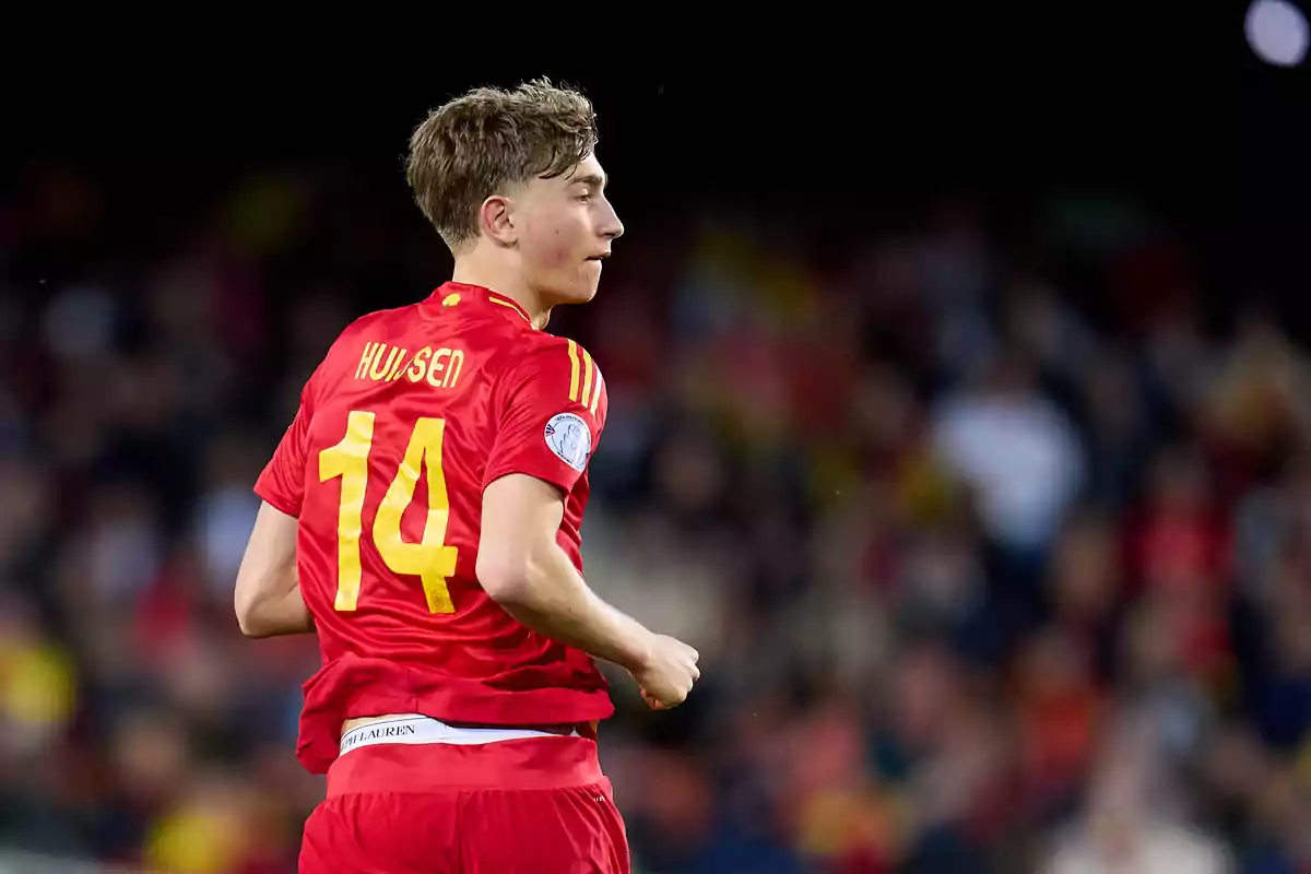 Jugador de fútbol con uniforme rojo y el número 14 en la espalda durante un partido Jugador de fútbol con uniforme rojo y el número 14 en la espalda durante un partido