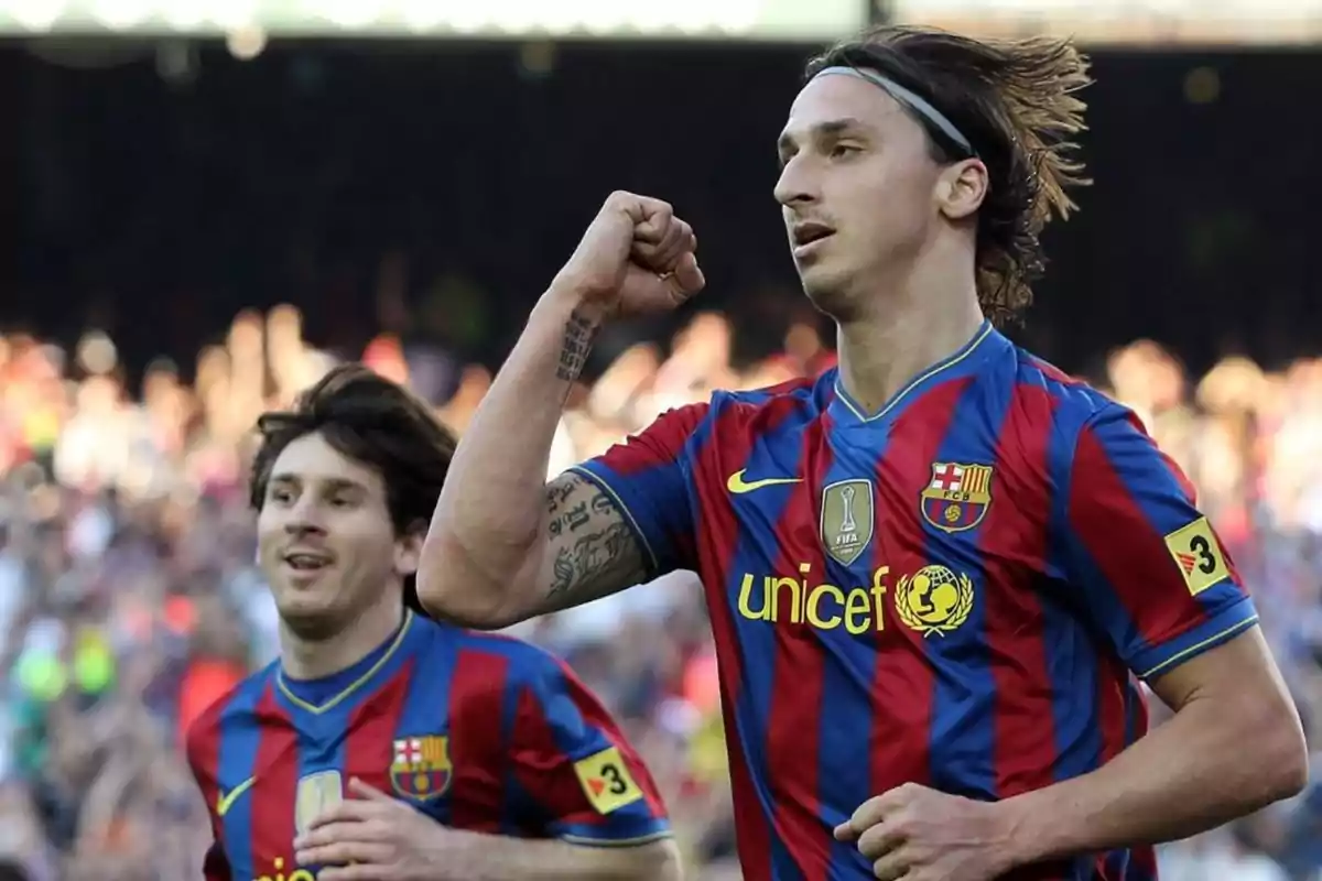 Dos jugadores de fútbol del FC Barcelona celebrando un gol en el campo.