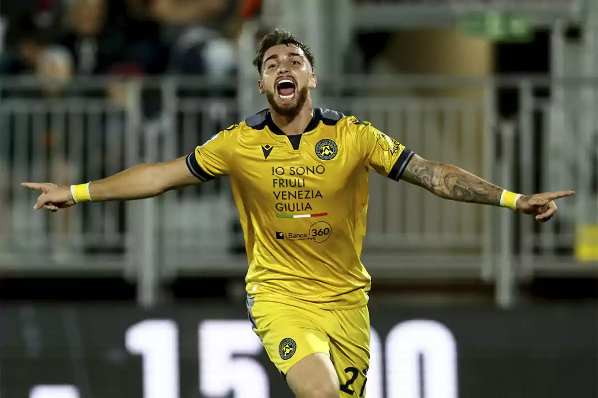 Iker Bravo celebrating a goal with his arms outstretched and wearing a yellow uniform. Iker Bravo celebrating a goal with his arms outstretched and wearing a yellow uniform.