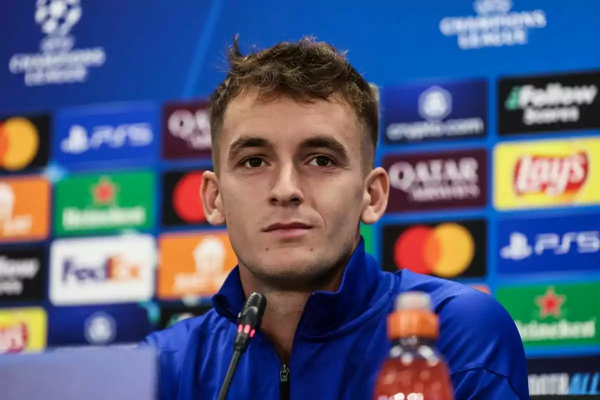 Un hombre en una conferencia de prensa con un fondo de logotipos de la UEFA Champions League.