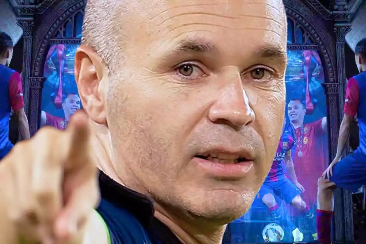 Andrés Iniesta con el dedo apuntando hacia delante con una imagen suya al fondo