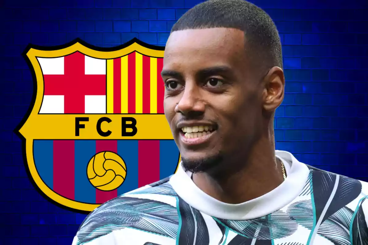 A smiling man in front of the FC Barcelona crest with a blue background.