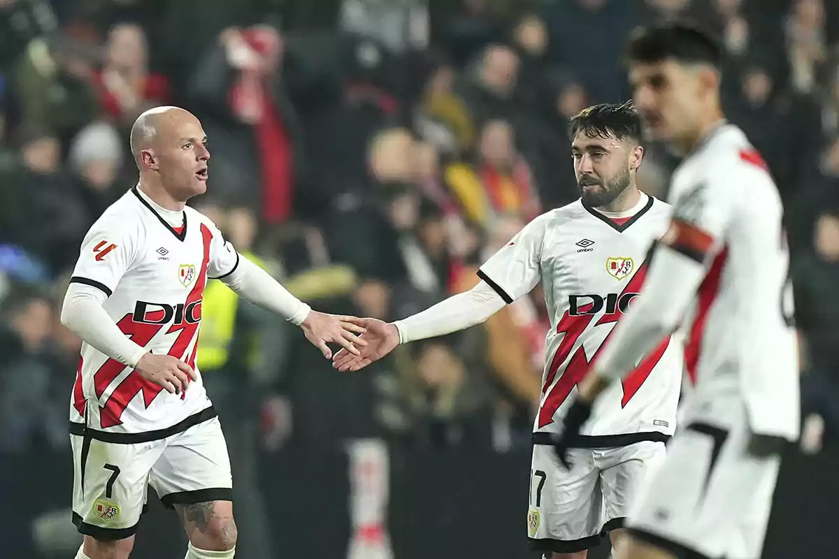 Jugadores de fútbol del Rayo Vallecano celebrando en el campo durante un partido.