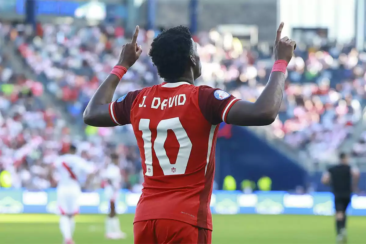 Jonathan David con camiseta roja número 10 celebrando en un estadio.