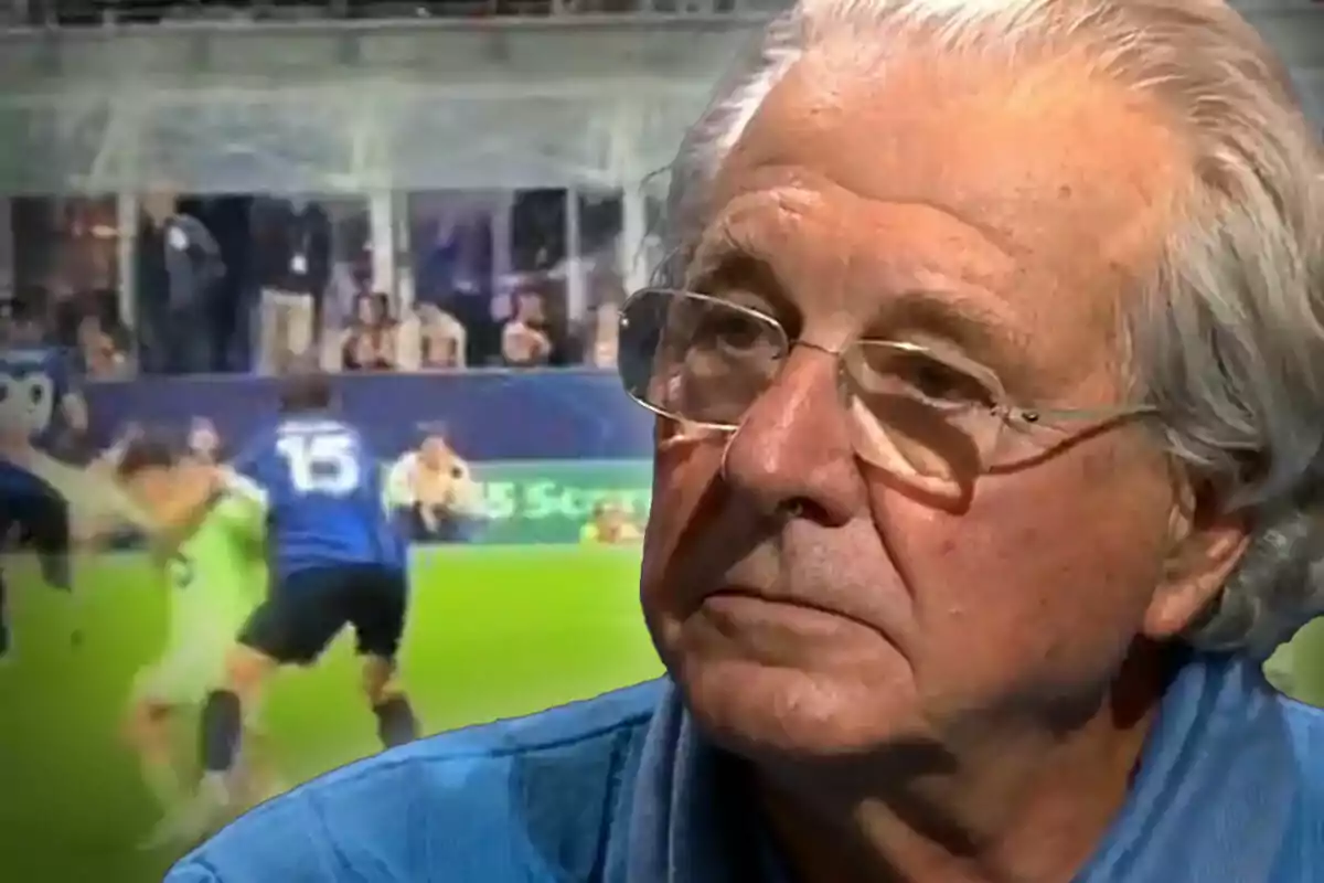 Un hombre mayor con gafas aparece en primer plano mientras de fondo se observa una escena de un partido de fútbol.