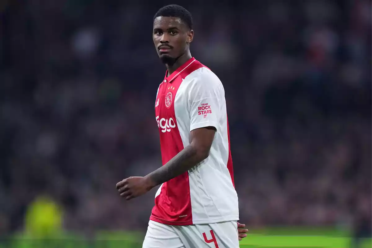 Jugador de fútbol con uniforme del Ajax en el campo durante un partido.