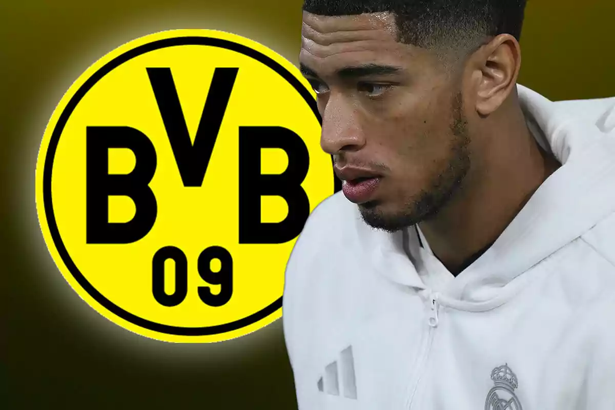 Un hombre con sudadera blanca frente al logo del Borussia Dortmund.