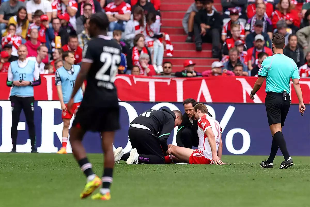 Kane en el suelo, atendido por los médicos del Bayern