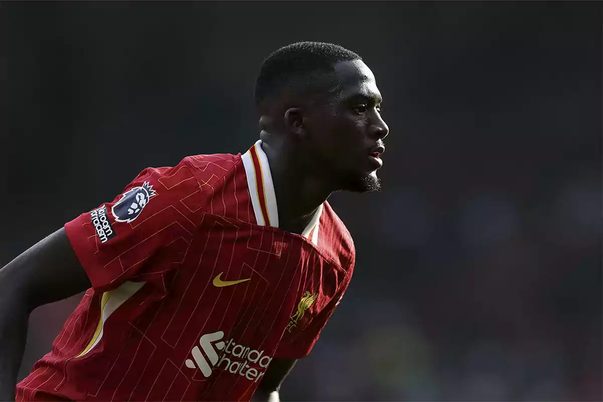 Un jugador de fútbol con uniforme rojo en el campo.