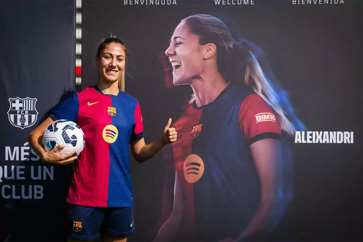 Futbolista del FC Barcelona femenino posando con un balón y haciendo el gesto de pulgar arriba frente a un cartel de bienvenida con su imagen y su apellido Aleixandri Futbolista del FC Barcelona femenino posando con un balón y haciendo el gesto de pulgar arriba frente a un cartel de bienvenida con su imagen y su apellido Aleixandri