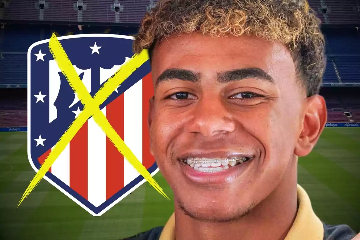 A smiling young man with braces in front of an Atlético de Madrid crest crossed out with a yellow X in a football stadium.