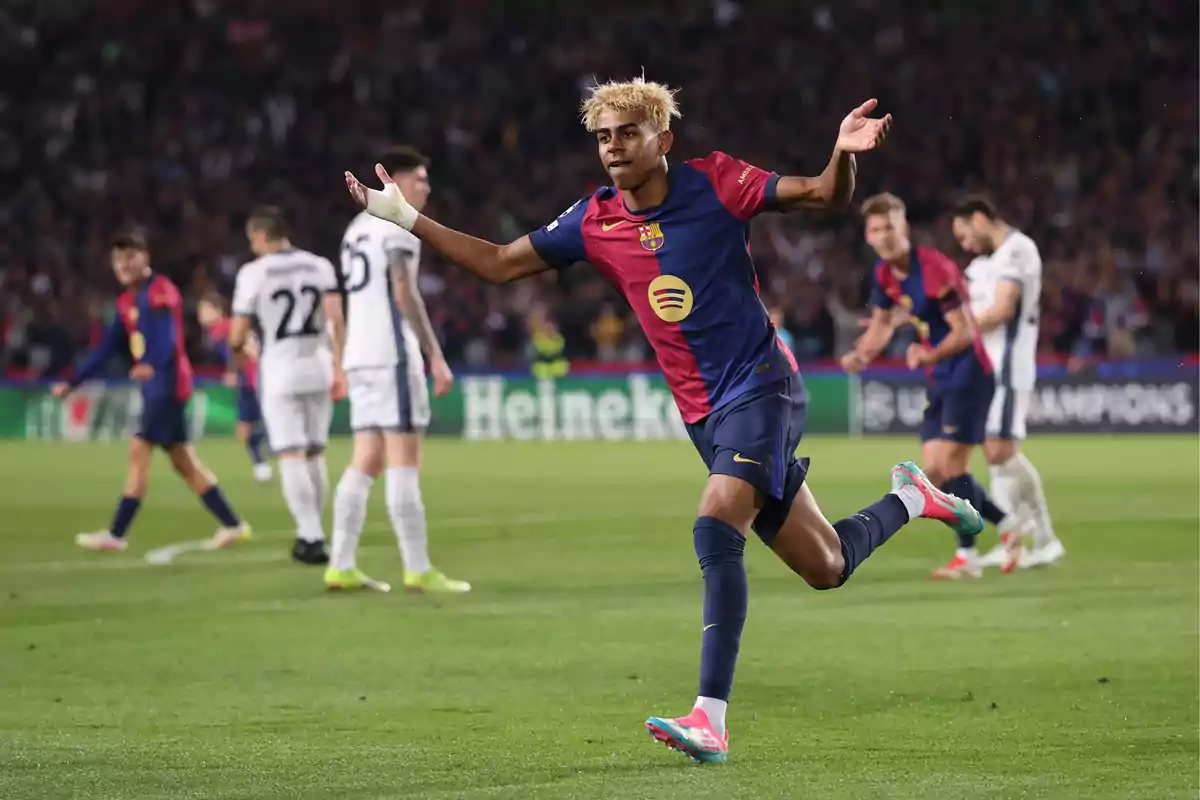 Un jugador de fútbol celebra un gol en el campo mientras otros jugadores están en el fondo. Un jugador de fútbol celebra un gol en el campo mientras otros jugadores están en el fondo.