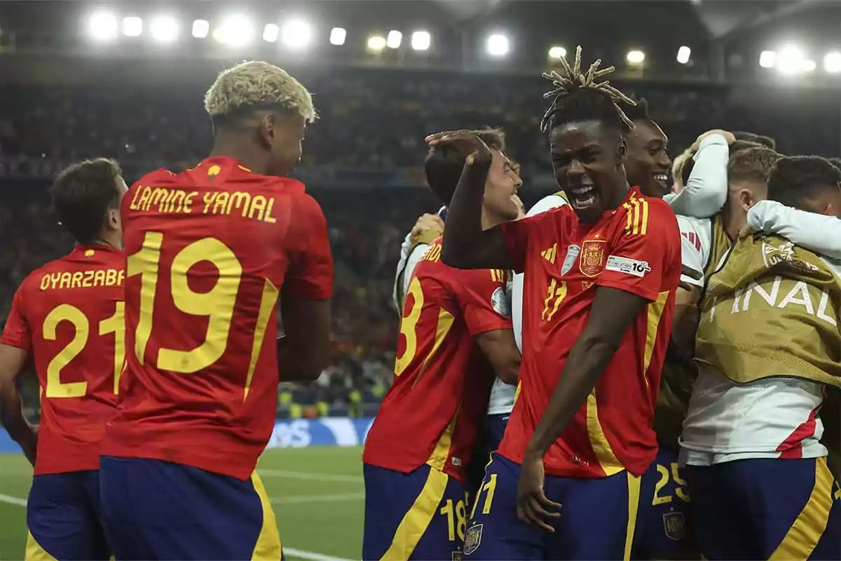 Jugadores de la selección española de fútbol celebran un gol en un estadio iluminado durante un partido importante Jugadores de la selección española de fútbol celebran un gol en un estadio iluminado durante un partido importante