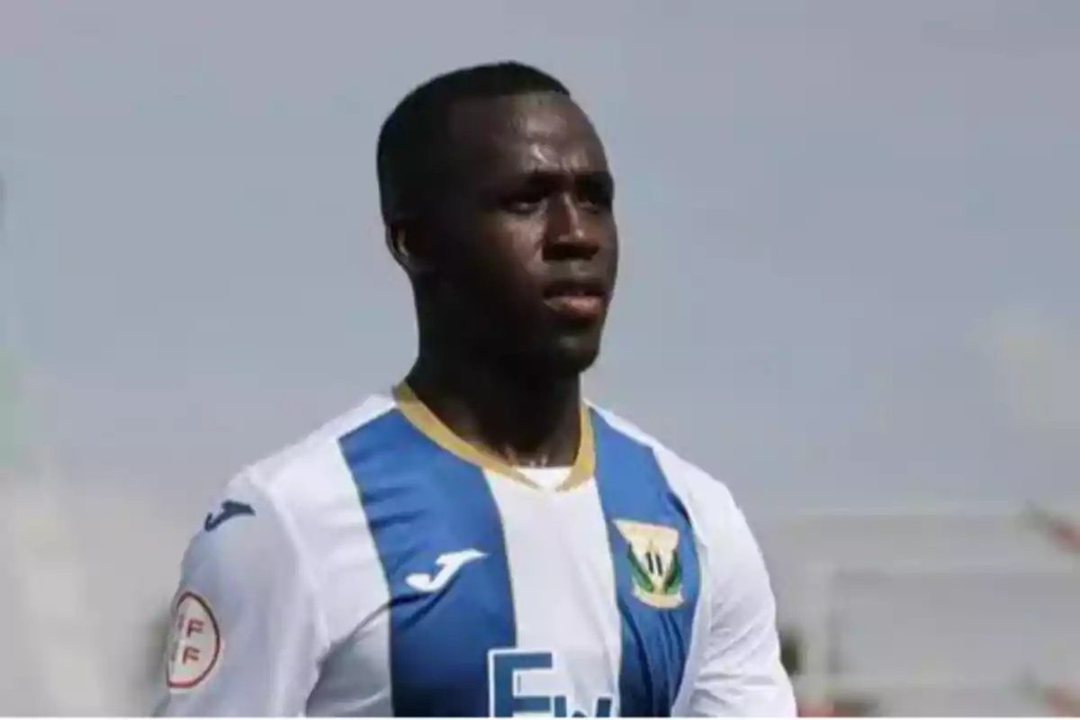 A soccer player in a white and blue uniform on the field.