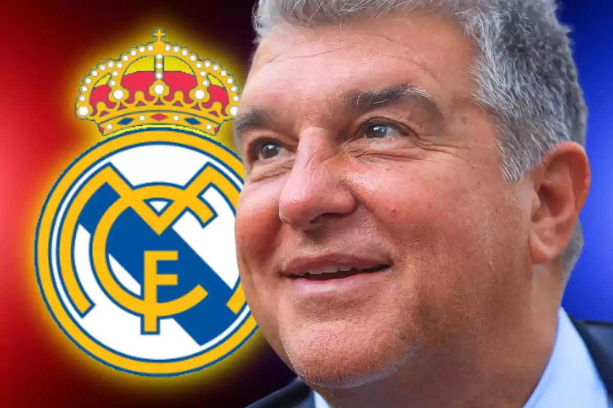 Un hombre sonriente con el escudo del Real Madrid de fondo.