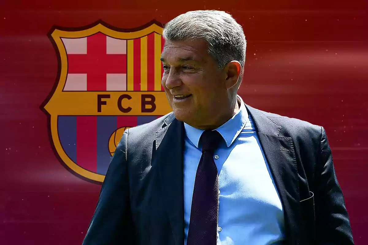 Joan Laporta con traje y corbata sonriendo frente al escudo del FC Barcelona.