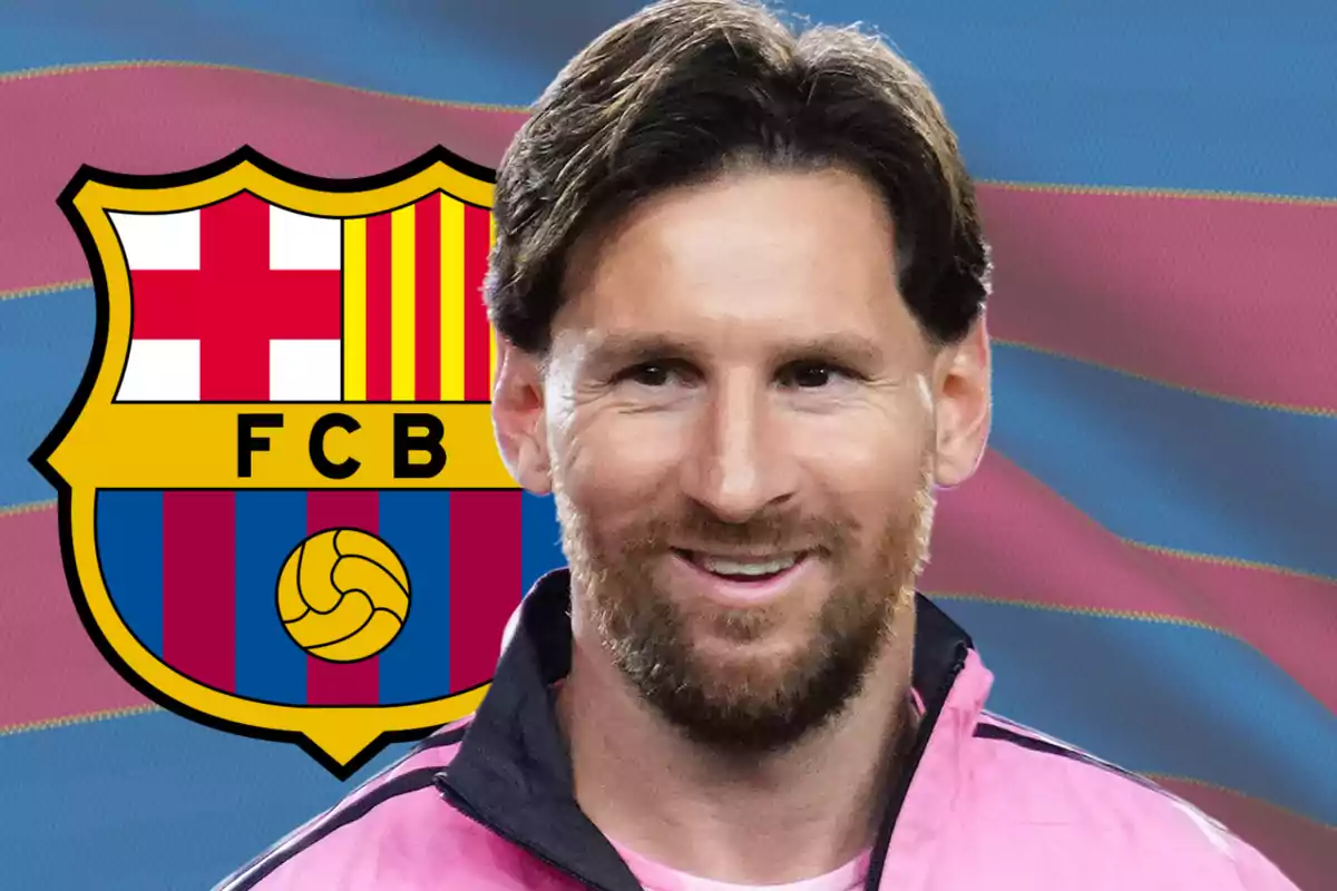 A smiling man in a pink jacket in front of a soccer team's emblem.