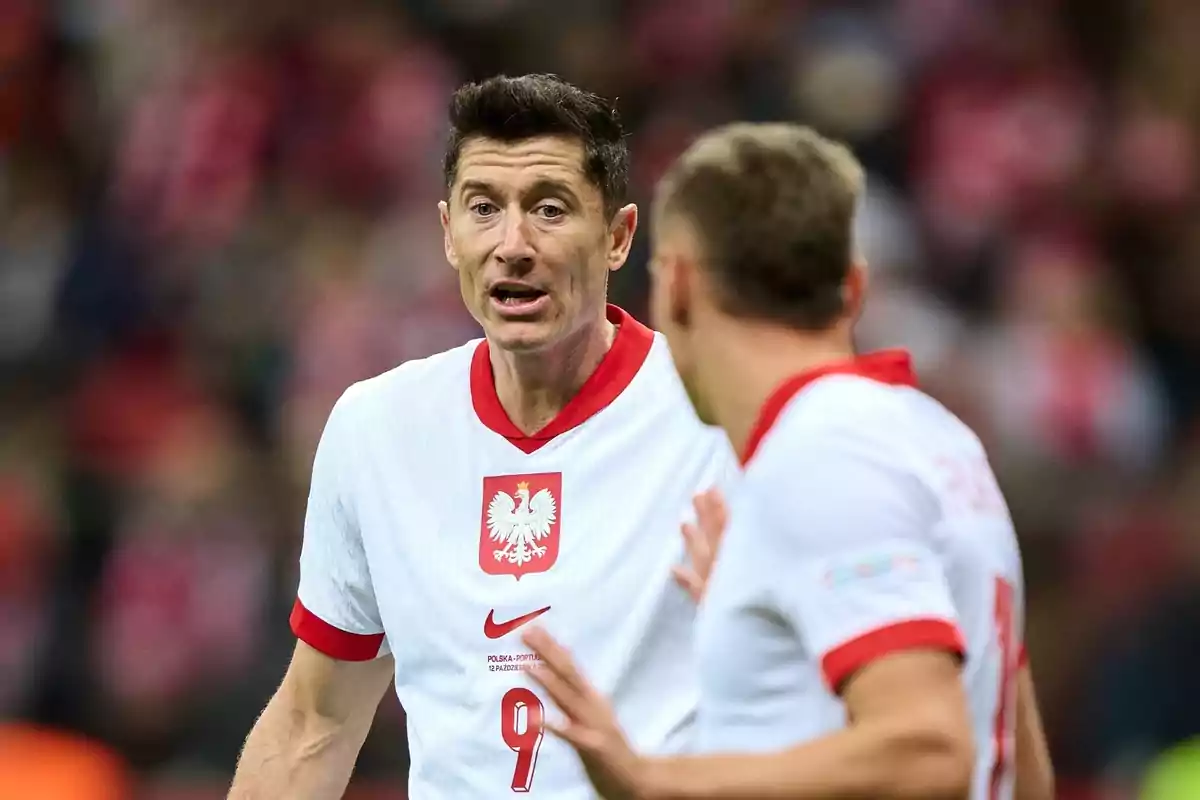 Dos futbolistas de la selección de Polonia conversan en el campo durante un partido
