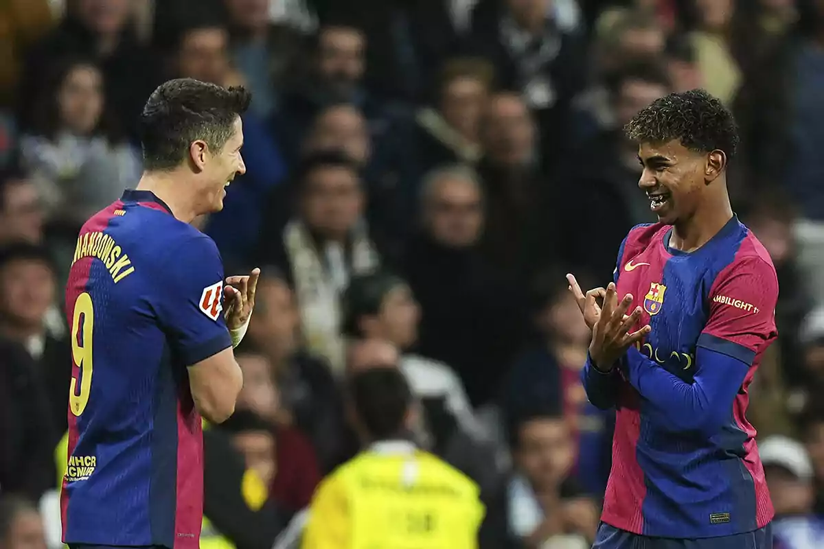 Two Barcelona soccer players celebrate on the field during a match.