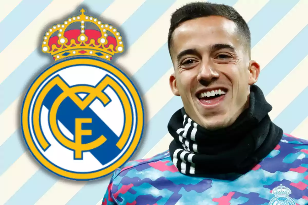 A smiling man wearing a black scarf and a colorful T-jersey, next to the Real Madrid crest on a background of blue and white diagonal stripes.