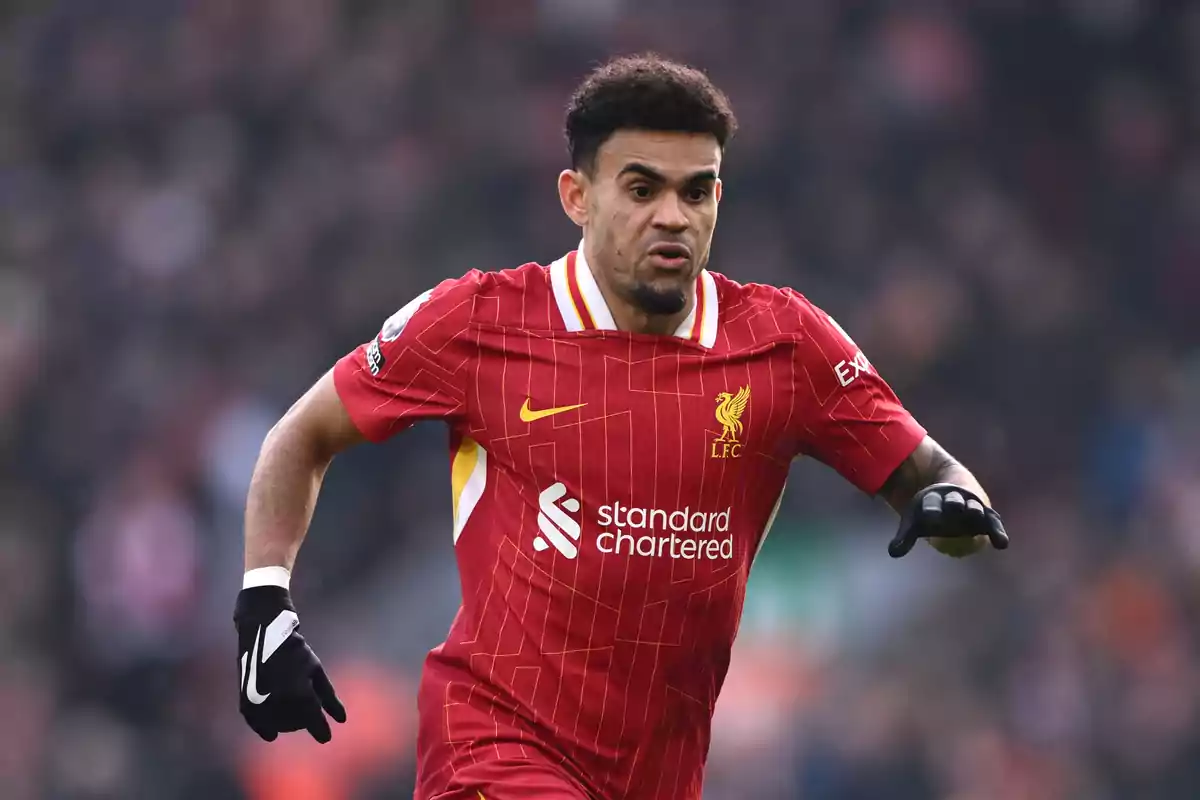 A player in the red Liverpool FC uniform running on the field during a match.