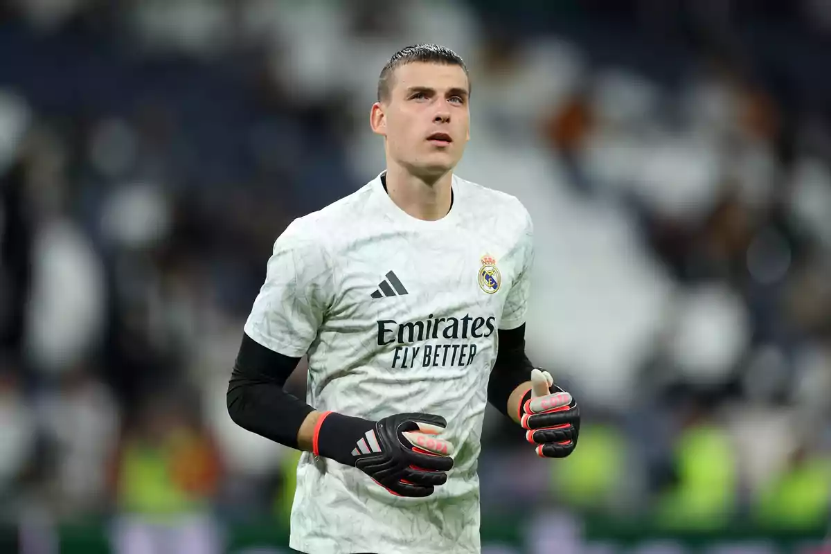 A football player in a Real Madrid goalkeeper uniform on the field.