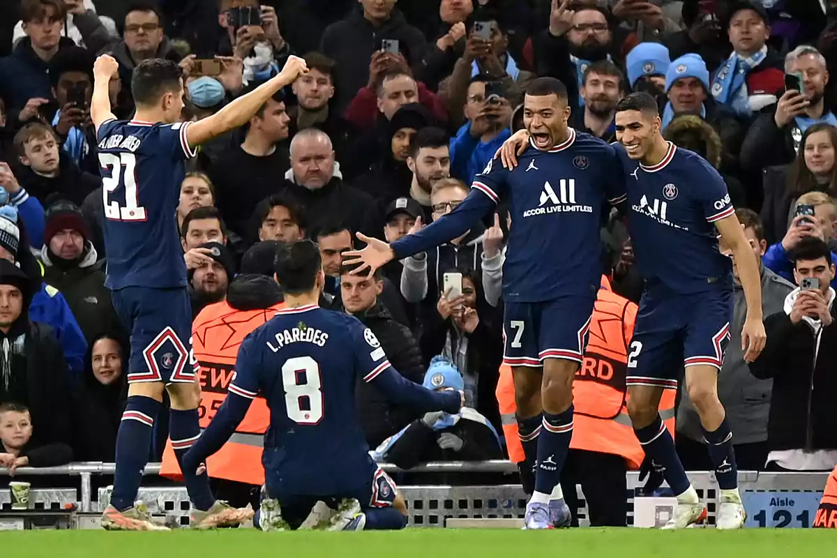 soccer players celebrate a goal in a stadium full of fans.