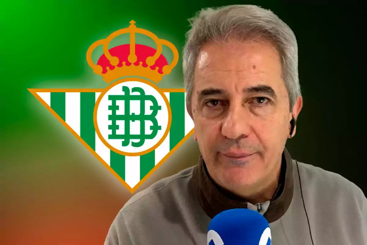 Un hombre con un micrófono azul frente al logo del Real Betis.