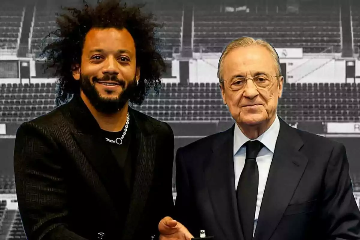 Dos hombres posan juntos en un estadio vacío, uno con cabello rizado y barba, el otro con gafas y traje.