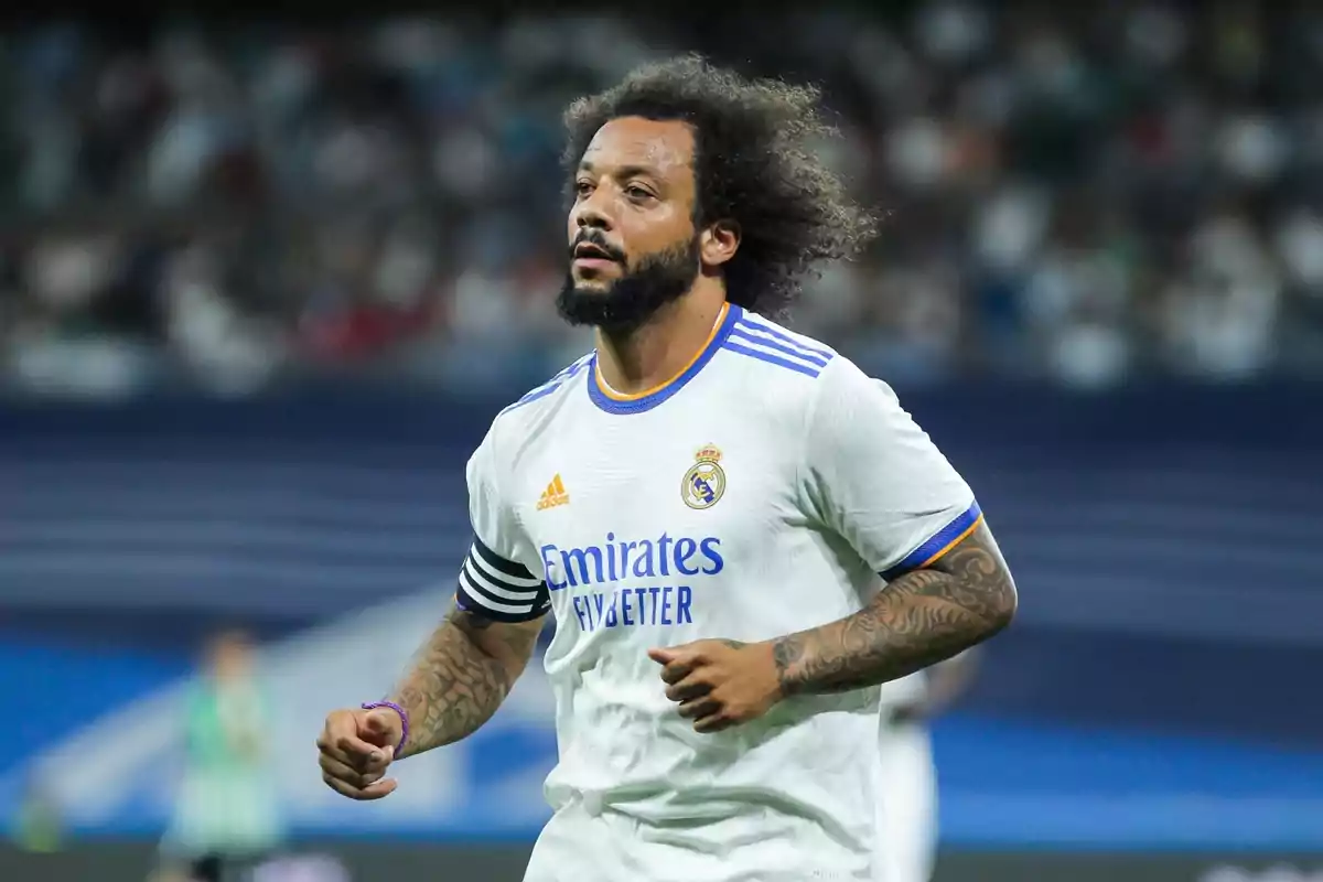 Soccer player in white uniform and captain's armband in a stadium. Soccer player in white uniform and captain's armband in a stadium.