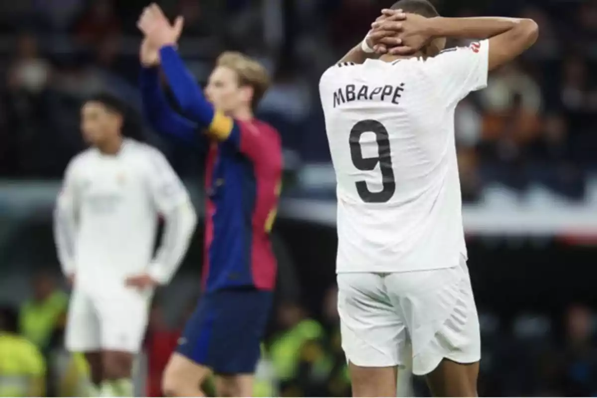 Jugador de fútbol con camiseta blanca y el número 9 en la espalda se lleva las manos a la cabeza mientras otros jugadores están en el fondo.