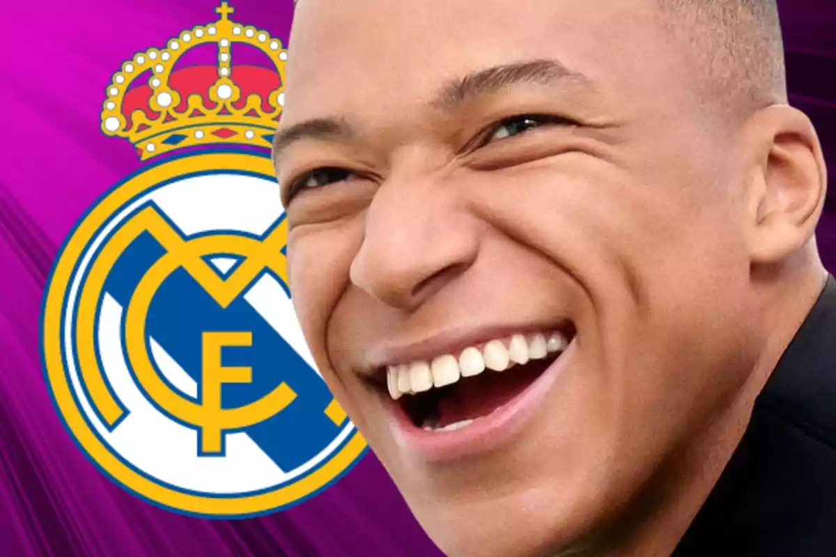 Kylian Mbappé con una gran sonrisa al lado de un escudo del Real Madrid