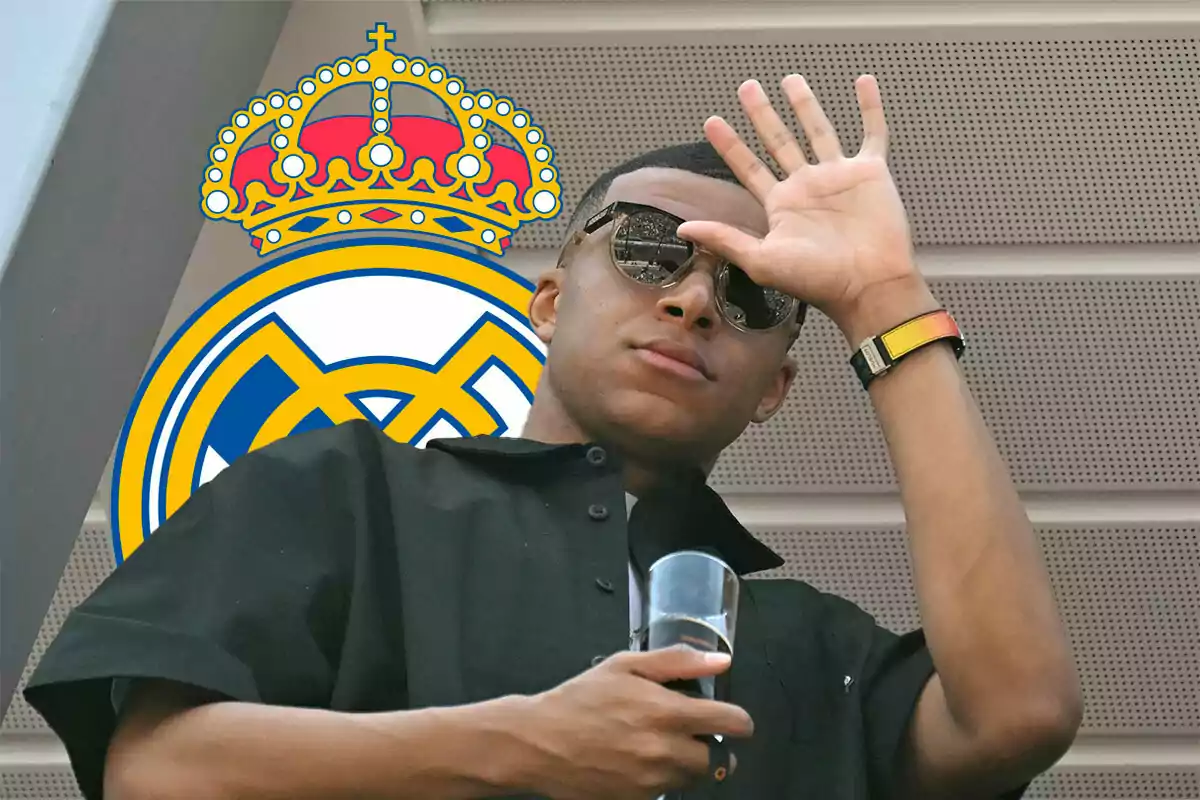 Mbappé saludando, detrás el escudo del Real Madrid