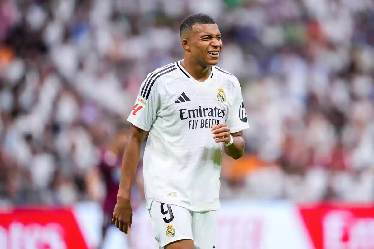 A football player in a Real Madrid uniform on the pitch.