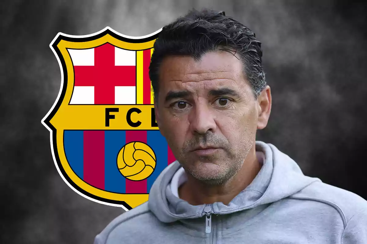 Míchel Sánchez in grey sweatjersey in front of FC Barcelona crest.