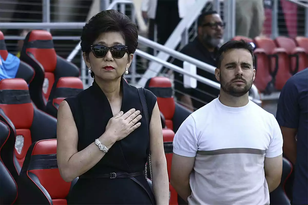 Michelle Kang placing her hand on her chest, next to Jonatan Giráldez.