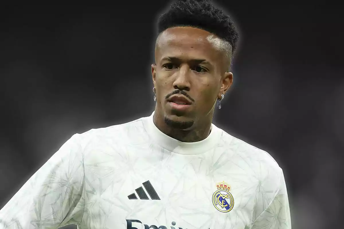 A soccer player wearing a Real Madrid jersey on a dark background.