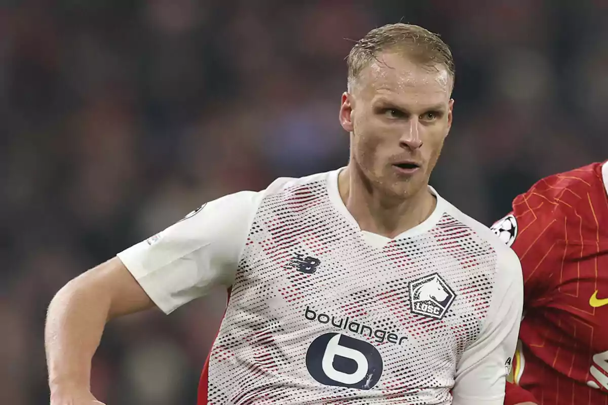 A football player in a white jersey of LOSC Lille team in action during a match. A football player in a white jersey of LOSC Lille team in action during a match.