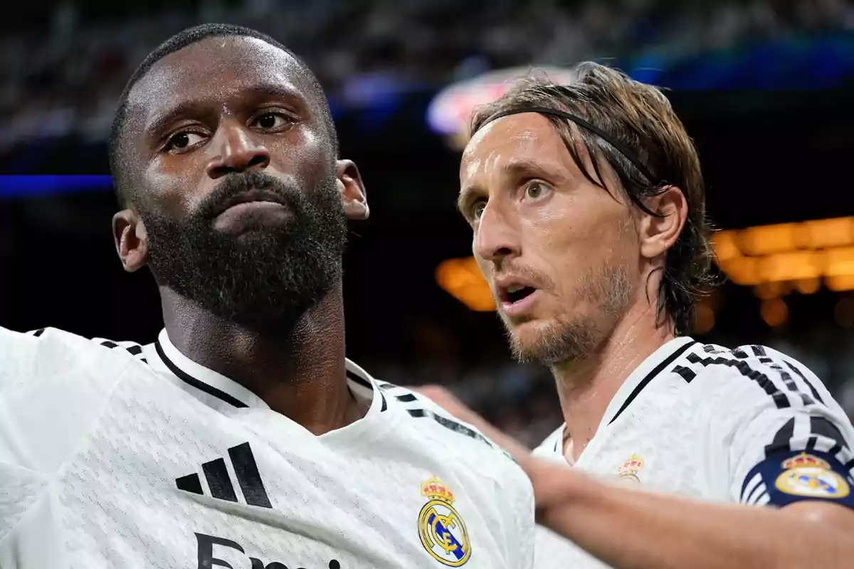 Dos jugadores de fútbol del Real Madrid, uno con barba y el otro con una cinta en el cabello, están en el campo durante un partido.