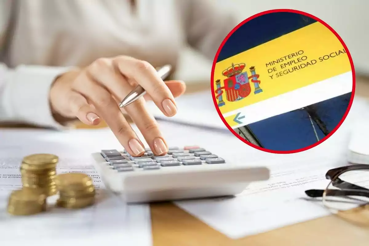 Persona usando una calculadora con monedas apiladas y un cartel del Ministerio de Empleo y Seguridad Social de España.