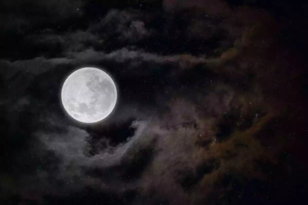 A dark night sky with clouds, stars and the full moon A dark night sky with clouds, stars and the full moon