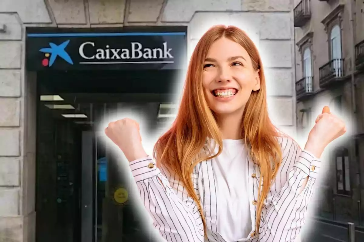 Una mujer sonriente con los puños levantados frente a una sucursal de CaixaBank.